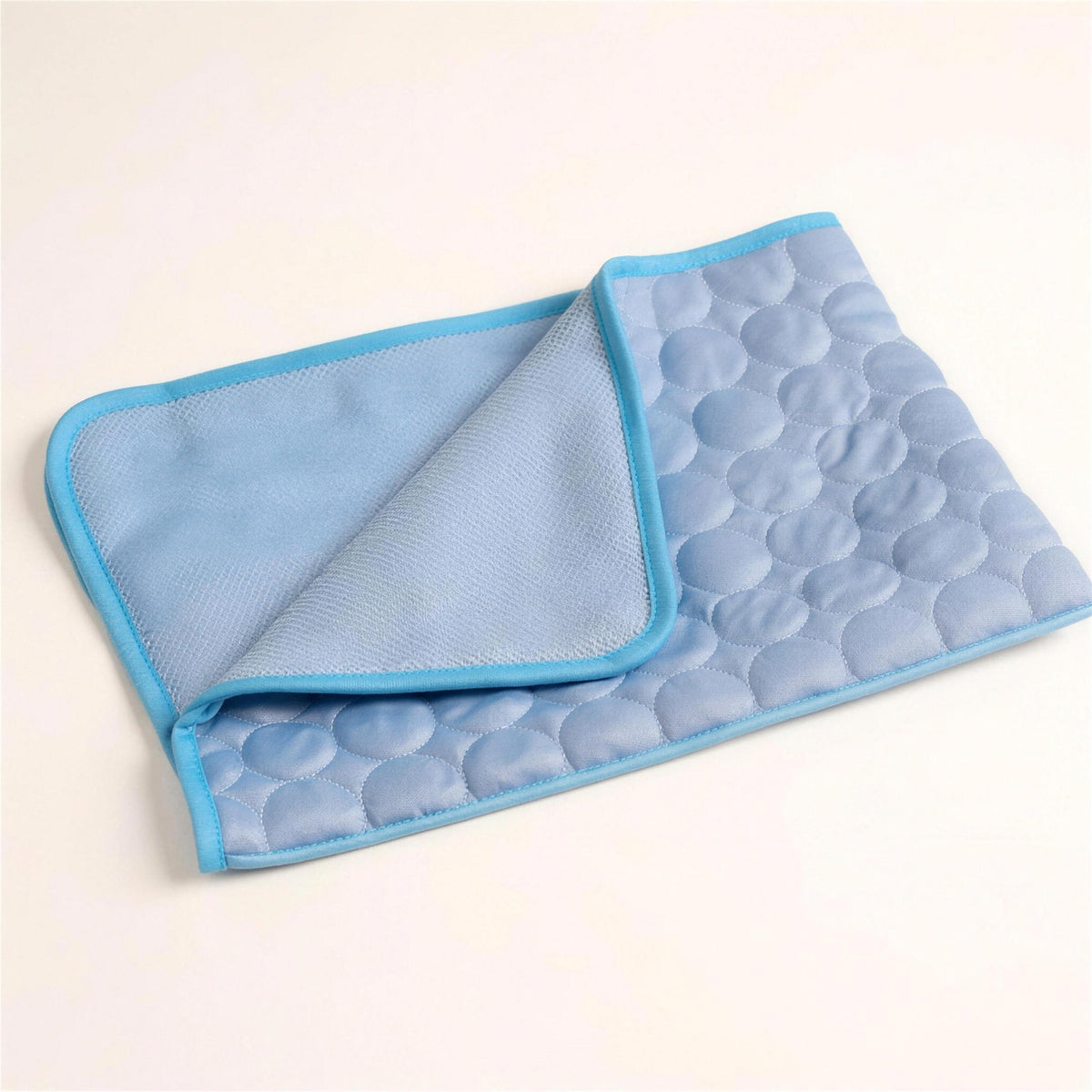 The ChillMat folded to show the quilted top and the grey mesh backing