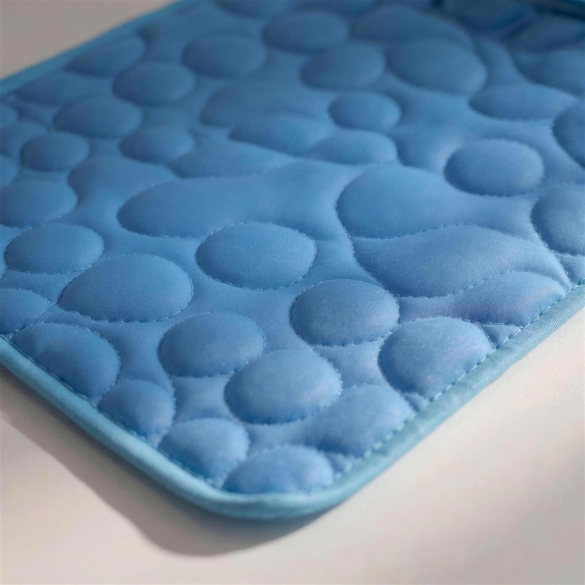 Close-up of the quilted ice-silk surface and the bound edge stitching